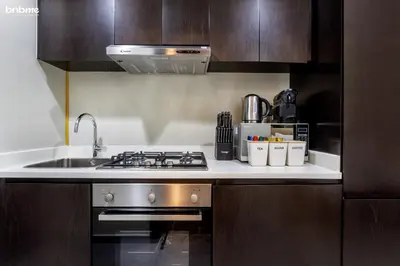 a kitchen with a sink and a stove top oven at bnbmehomes - Merano Tower in Dubai