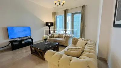 a living room with two couches and a tv at Canal View 2BR & Maid Room in KG Tower, Dubai Marina in Dubai