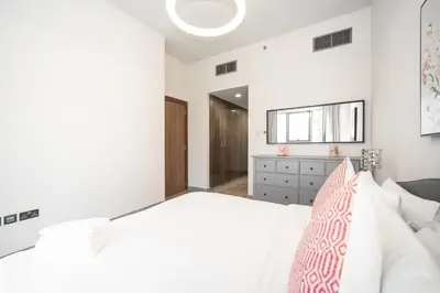 a bedroom with a white bed and a window at Tranquil Retreat with Canal View 1BR MBL Residence - 29AB12 in Dubai