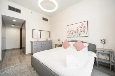 a bedroom with a large white bed with pink pillows at Tranquil Retreat with Canal View 1BR MBL Residence - 29AB12 in Dubai
