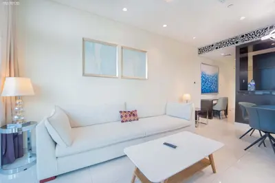 a living room with a white couch and a table at Downtown Damac Distinction Full Burj View in Dubai