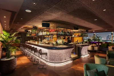 a bar in a restaurant with a view of the city at Hilton Dubai Palm Jumeirah in Dubai