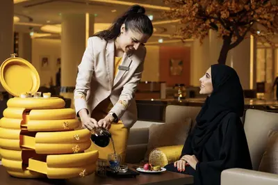 a woman standing next to a woman cutting a cake at Hilton Dubai Palm Jumeirah in Dubai
