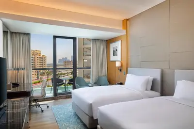 two beds in a hotel room with a view at Hilton Dubai Palm Jumeirah in Dubai