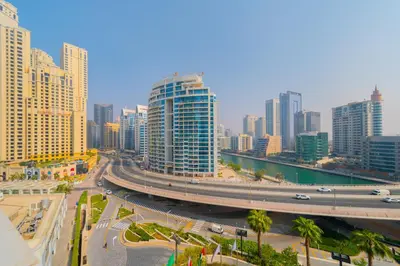 a city with a highway in front of tall buildings at EDEN'S Homes & Villas - ADDRESS BEACH Residences JBR in Dubai