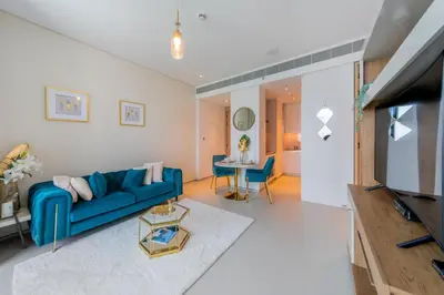 a living room with a blue couch and a table at EDEN'S Homes & Villas - ADDRESS BEACH Residences JBR in Dubai