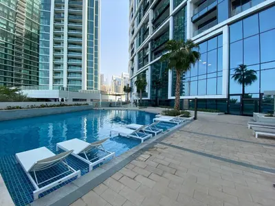 a swimming pool with lounge chairs in a building at EDEN'S Homes & Villas - ADDRESS BEACH Residences JBR in Dubai