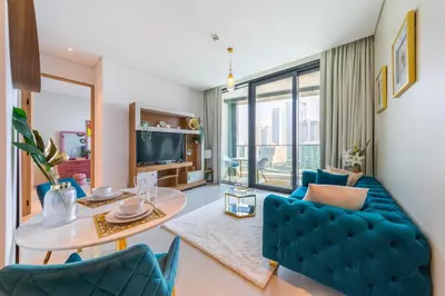 a living room with a blue couch and a table at EDEN'S Homes & Villas - ADDRESS BEACH Residences JBR in Dubai