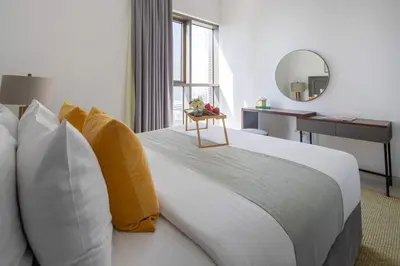 a bedroom with a large bed with pillows and a mirror at Frank Porter - Creekside18 in Dubai