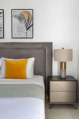 a bedroom with a bed with a yellow pillow and a lamp at Frank Porter - Creekside18 in Dubai