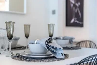 a dining room table with a blue napkin on top of it at EDEN'S Homes & Villas - Atria Residences in Dubai