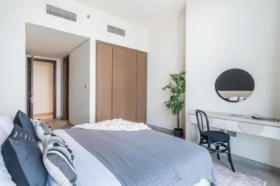 a bedroom with a bed and a desk and a chair at EDEN'S Homes & Villas - Atria Residences in Dubai