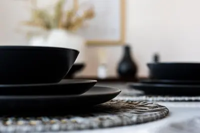 a group of black bowls sitting on a table at EDEN'S Homes & Villas - Atria Residences in Dubai