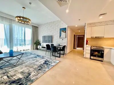 a kitchen and living room with a table and chairs at Ultimate Luxury at Dubai Creek Horizon Waterfront in Dubai