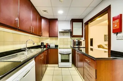 a kitchen with wooden cabinets and a sink at Wonderful 2 Bedroom apartment in JBR in Dubai