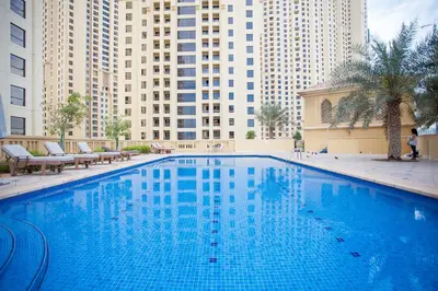 a large blue swimming pool in front of tall buildings at Wonderful 2 Bedroom apartment in JBR in Dubai