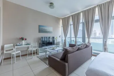 a living room with a couch and a table and a television at Frank Porter - Indigo Tower in Dubai