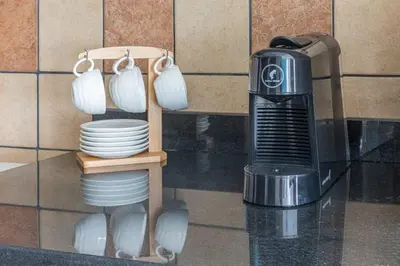 a kitchen with a coffee maker and plates and mugs at Frank Porter - Indigo Tower in Dubai