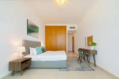 a bedroom with a bed and a desk and a table at Manazel Al Safa in Dubai in Dubai