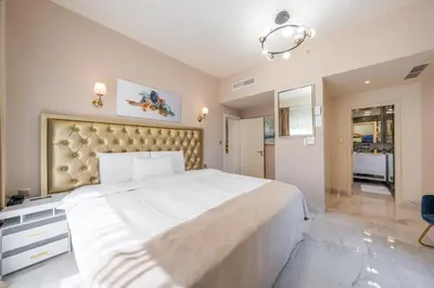 a bedroom with a large white bed with a large headboard at Magic waves holiday in Dubai