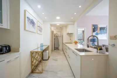 a white kitchen with a sink and a counter at Magic waves holiday in Dubai