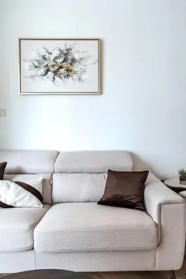 a couch in a living room with a painting on the wall at GuestReady - Marina Views | 1BR + Pool & Gym in Dubai