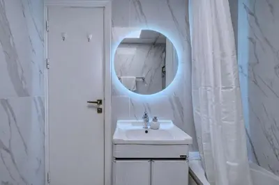 a white bathroom with a sink and a mirror at GuestReady - Marina Views | 1BR + Pool & Gym in Dubai