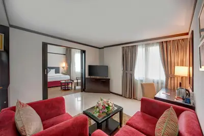 a living room with a red couch and a television at Grandeur Hotel Al Barsha in Dubai