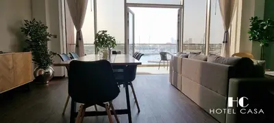 a living room with a couch and a table with chairs at Palm Jumeirah 1BR luxurious & gorgeous view in Dubai