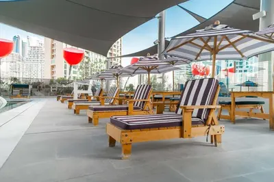 a row of wooden chairs and umbrellas on a patio at Frank Porter - MAG 318 in Dubai