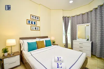 a bedroom with a large white bed with blue pillows at Luxury Escapes - Budget Cozy Studio in Dubai Gate 2 JLT in Dubai