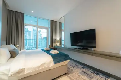 a hotel room with a large bed and a flat screen tv at AWS Holiday Homes - Panoramic Canal View in Dubai