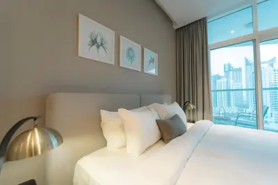 a bedroom with a white bed with a large window at AWS Holiday Homes - Panoramic Canal View in Dubai