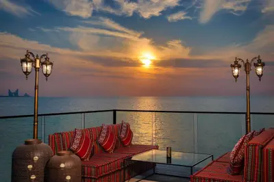 a balcony with chairs and a table and the ocean at Anantara World Islands Dubai Resort in Dubai