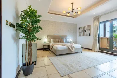 a bedroom with a bed and a potted plant at Luxury Beachfront Villa with Direct Beach Access, Next to Community Pool, Close to the Thrills of Aquaventure Waterpark, Canal Cove, Palm Jumeirah by Deluxe Holiday Homes in Dubai
