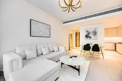 a living room with a white couch and a table at Brand New 5* Luxury Apartment in Address JBR in Dubai