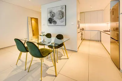 a kitchen and dining room with a glass table and chairs at Brand New 5* Luxury Apartment in Address JBR in Dubai