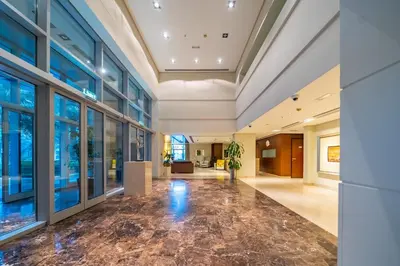 an office lobby with glass doors and a marble floor at Chic and Zen Apartment, Near Burj Khalifa Tower in Dubai