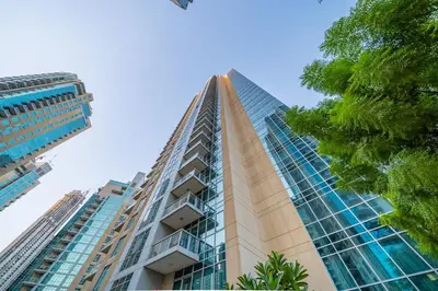 a tall building with glass windows and a tree at Chic and Zen Apartment, Near Burj Khalifa Tower in Dubai