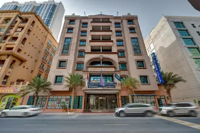 a tall building with cars in front of it at Orchid Hotel Al Barsha 