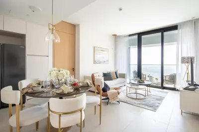 a dining room and living room with a table and chairs at Frank Porter - The Address JBR in Dubai