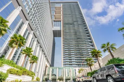 a tall building with palm trees in front of it at Silkhaus studio in DIFC with Burj Khalifa view, pool & gym in Dubai