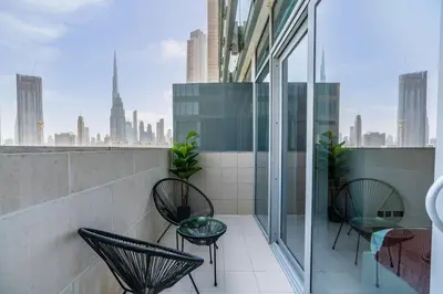 a balcony with chairs and a view of the city at Silkhaus studio in DIFC with Burj Khalifa view, pool & gym in Dubai