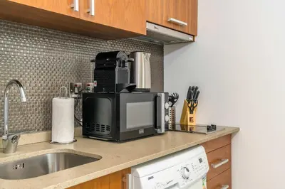 a kitchen counter with a microwave and a sink at Silkhaus newly furnished studio facing DIFC with pool and gym access in Dubai