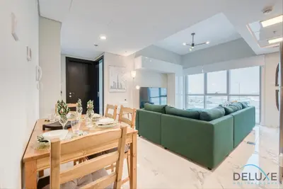a living room with a green couch and a table at Peaceful 1BR at MAG 505 Dubai South by Deluxe Holiday Homes in Dubai