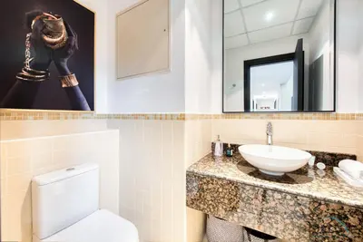 a bathroom with a sink and a toilet and a mirror at Elegant 2BR at Bahar 2 JBR by Deluxe Holiday Homes in Dubai