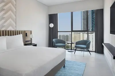 a hotel room with a bed and two chairs at Courtyard by Marriott World Trade Centre, Dubai in Dubai