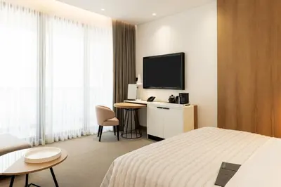 a hotel room with a bed and a flat screen tv at Le Royal Meridien Beach Resort & Spa Dubai in Dubai