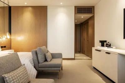 a bedroom with a bed and a chair and a kitchen at Le Royal Meridien Beach Resort & Spa Dubai in Dubai