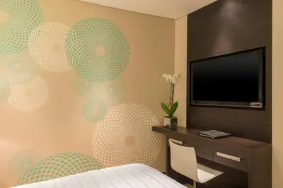 a bedroom with a bed and a desk and a television at Le Royal Meridien Beach Resort & Spa Dubai in Dubai